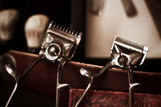 Vintage hair clippers resting on the barber's leather strop