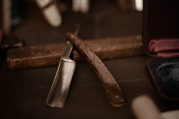 A straight razor resting on its leather strop